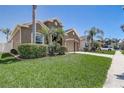 Landscaped front yard with palm trees, well-manicured lawn and exterior with a two-car garage at 2827 Moonstone Bnd, Kissimmee, FL 34758