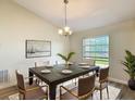 Dining room features a modern table, six chairs, stylish chandelier, and large window at 2984 Monica Ter, Kissimmee, FL 34744