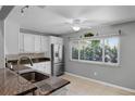 Bright kitchen featuring white cabinets, stainless steel appliances, and a window overlooking the backyard at 314 E Bonnie Trl, Longwood, FL 32750