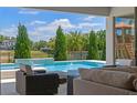 View of a luxurious in-ground pool with waterfall feature and outdoor seating area at 327 Island Sound Ct, Longwood, FL 32779