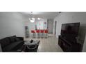 Living room features tiled floors, gray couch and adjacent breakfast bar with four red barstools at 3379 S Kirkman Rd # 1015, Orlando, FL 32811