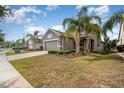 View of well-maintained single-Gathering homes with manicured lawns and mature palm trees at 3443 Sagebrush St, Harmony, FL 34773