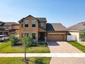 Beautiful two-story home with a brick driveway, landscaped yard, and an attached two-car garage at 3450 Puxton Dr, Orlando, FL 32824