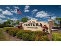 Ventura Country Club sign features an American flag and manicured landscaping under a bright blue sky at 3960 Southpointe Dr # 501, Orlando, FL 32822