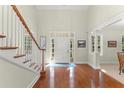 Bright and airy foyer with hardwood floors, a staircase, and a view of the front door and windows at 4000 Rouse Rd, Orlando, FL 32817