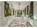 Inviting front porch featuring white rocking chairs and a beadboard ceiling with fans, perfect for relaxation at 4000 Rouse Rd, Orlando, FL 32817