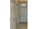 Bright entryway featuring tiled floors, chandelier lighting, and a white front door at 4058 Brookshire Cir, Eustis, FL 32736