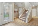 Welcoming foyer with wood flooring, stairs, and a glass-paneled front door at 5341 Via Appia Way, Sanford, FL 32771