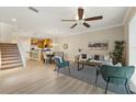 Open-concept living room with dining area, ceiling fan, and stairs leading to the second floor at 5341 Via Appia Way, Sanford, FL 32771