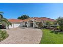 Inviting single-story home with a terra cotta roof, three-car garage, and beautifully landscaped front yard at 709 Cricklewood Ter, Lake Mary, FL 32746