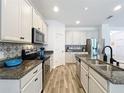 Well-lit kitchen with granite countertops, stainless steel appliances, and decorative backsplash at 865 Bay Bridge Cir, Apopka, FL 32703