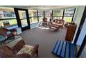 Bright sunroom furnished with comfortable wicker seating and large windows offering natural light at 951 Cr 453, Lake Panasoffkee, FL 33538