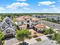 A stately two-story home with a terracotta roof near a scenic highway in a luxury neighborhood at 971 Golden Bear Dr, Reunion, FL 34747