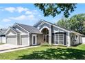 Beautiful single-story home with lush green lawn, mature trees, and inviting front entrance at 1008 W Riviera Blvd, Oviedo, FL 32765