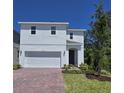 Charming two-story home with a red brick driveway, a two-car garage, and a well-manicured lawn at 1096 Happy Forest Loop, Deland, FL 32720