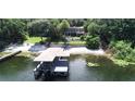 Waterfront home featuring a covered dock, beach area and wooded area with multi-story home at 1105 Lake Nettie Dr, Eustis, FL 32726