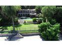 Expansive backyard featuring lush landscaping, a sparkling pool, and multi-story home at 1105 Lake Nettie Dr, Eustis, FL 32726