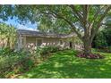 Landscaped front yard with a large shade tree and well maintained lawn at 1105 Lake Nettie Dr, Eustis, FL 32726