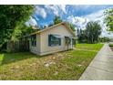Side view of cozy home featuring a well-manicured lawn and lovely blue awnings at 111 E Caroline St, Tavares, FL 32778