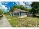 Quaint home featuring a well-maintained lawn and a charming blue awning at 111 E Caroline St, Tavares, FL 32778