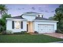 Exterior view of a new home with a well-manicured lawn, two-car garage, and a paver driveway at 1161 Basalt Ln, Sanford, FL 32771