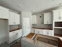 Bright kitchen featuring white cabinets, gray walls, and a center island awaiting finishing touches at 1161 Basalt Ln, Sanford, FL 32771