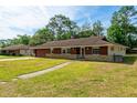Charming single-story home with a well-maintained lawn and stone accents, providing an inviting curb appeal at 1221 Adams St, Longwood, FL 32750