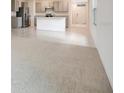 Open-concept living room with neutral carpet flowing into the kitchen with gray cabinets at 1221 August Sky Dr, Deltona, FL 32738