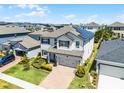 Aerial view of a beautifully landscaped two-story home with solar panels in a residential neighborhood at 13320 Magnolia Valley Dr, Clermont, FL 34711