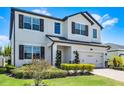 Attractive two-story home with a two-car garage, landscaped yard, and elegant architectural details at 13320 Magnolia Valley Dr, Clermont, FL 34711