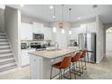 Bright kitchen with white cabinets, stainless steel appliances, granite countertops, and bar stool seating at 1540 Softshell St, St Cloud, FL 34771