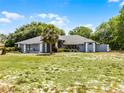 Desirable one-story home showcasing a bright red front door, mature trees, and large front lawn at 1689 Saboff Way, Chuluota, FL 32766