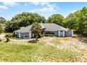 Inviting one-story home showcasing a bright red front door, mature trees, and large front lawn at 1689 Saboff Way, Chuluota, FL 32766