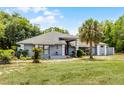 Inviting one-story home featuring lush green lawn, mature landscaping, and a side entry garage at 1689 Saboff Way, Chuluota, FL 32766