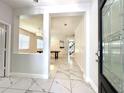 Inviting foyer with marble floors, an open floor plan, and a decorative glass front door at 2648 Needlepoint St, Kissimmee, FL 34741