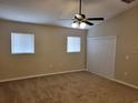 Bright bedroom with carpet, ceiling fan, neutral paint, and large windows with blinds at 266 Paradise Woods Ct, Davenport, FL 33896