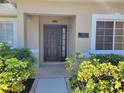Inviting front entrance with tiled walkway, manicured bushes, and address plaque near the door at 266 Paradise Woods Ct, Davenport, FL 33896