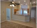 Open living room area featuring tile flooring, with view to the kitchen and breakfast bar at 266 Paradise Woods Ct, Davenport, FL 33896