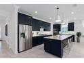 Stylish kitchen with dark blue cabinets, a central island with seating, and stainless steel appliances at 2725 Serenity Meadow Dr, Kissimmee, FL 34744