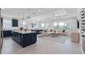 Open-concept living room and kitchen featuring an island, modern lighting, and seamless flow to the outdoors at 2725 Serenity Meadow Dr, Kissimmee, FL 34744