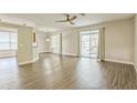 Open-concept living room with wood-look flooring and sliding glass doors to the lanai at 2765 Eldred Ct, Apopka, FL 32712