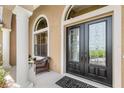 Close-up of the front door with decorative glass, stylish hardware, and a cozy seating area at 2825 Lakeshore Dr, Mount Dora, FL 32757