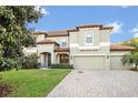 Beautiful two-story home with a tile roof, green lawn, and a two-car garage at 2860 Falconhill Dr, Apopka, FL 32712