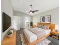 Stylishly furnished bedroom featuring a ceiling fan, sleek TV, and decor; bathroom access visible at 30442 Pga Dr, Sorrento, FL 32776