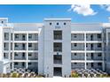 Modern condo building featuring a central entrance with multiple levels and exterior hallways at 3151 Paradox Cir # 108, Kissimmee, FL 34746