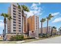 Sanibel Condominiums property residential complex with mature palm tree landscaping at 3799 S Atlantic Ave # 1006, Daytona Beach, FL 32118