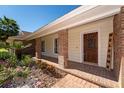 Close up of a charming front porch with brick columns and walkway, and a welcoming wooden door at 4464 Willow Wind Ct, Orlando, FL 32835