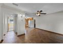 Open room with hardwood flooring flowing into a kitchen area with bright white appliances at 4816 Davisson Ave, Orlando, FL 32804