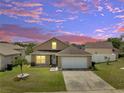 Beautiful sunset view of home with a well-manicured lawn at 5118 Luna Negra Dr, Orlando, FL 32811