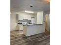 Bright kitchen featuring white cabinets, a breakfast bar, and wood-look vinyl plank flooring at 627 Dory Ln # 202, Altamonte Springs, FL 32714